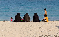 10 Iranian women with black chador on beach
