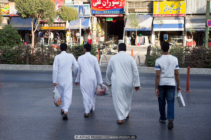 10 Men wearing dishdasha crossing the street