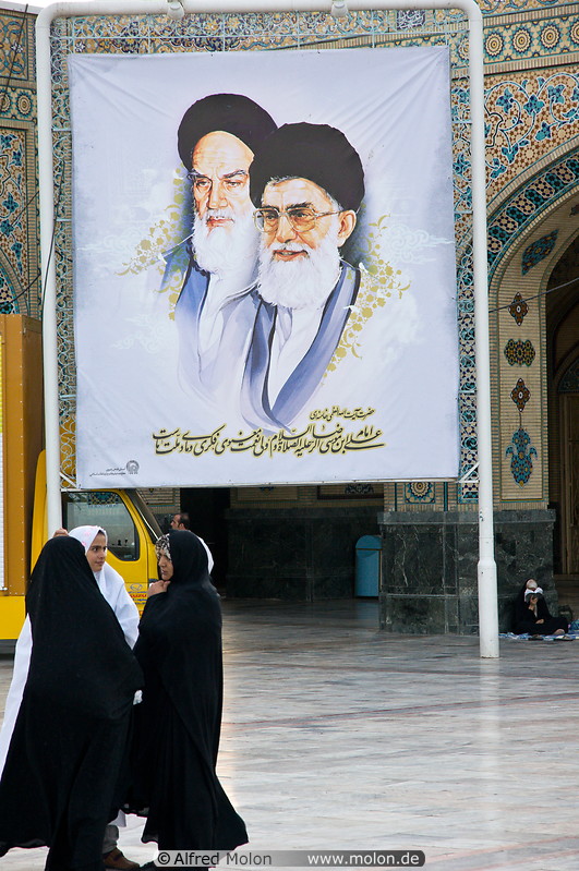 14 Women in front of poster of Ayatollahs Khomeini and Khamenei