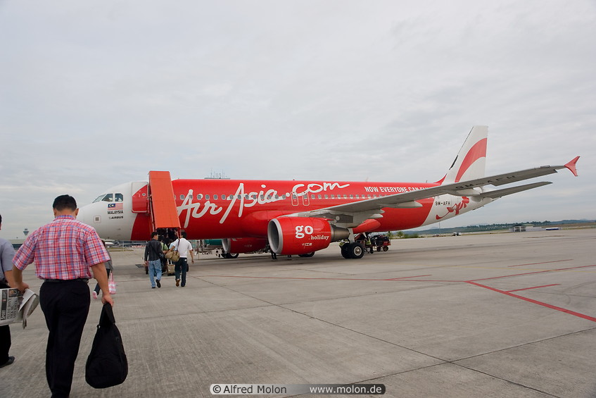 Photo of Travellers boarding red AirAsia jet. KL International Airport ...