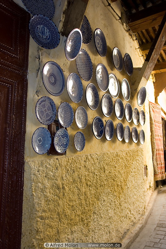11 Decorated blue plates on yellow wall