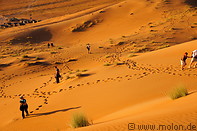 13 Tourists walking on sand dunes