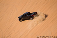 16 Pickup truck driving on sand dune
